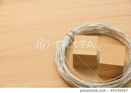 Cube wood and wire placed on a wooden board. 44149267