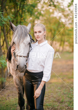 Young girl in uniform hugs her horse Young girl in uniform hugs her horse 44149944