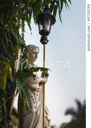 The angel with street lantern in dawn beams The angel with street lantern in dawn beams 44150249