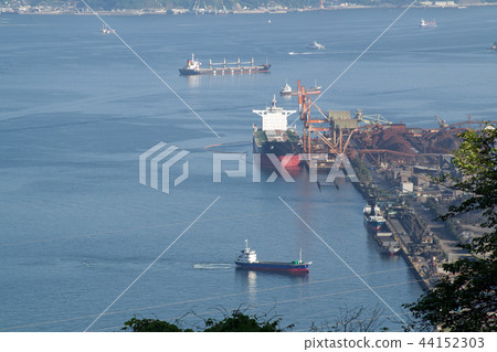 A view of a ship handling cargo at a steel mill 44152303