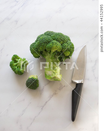 Green raw broccoli and knife Green raw broccoli and knife 44152995