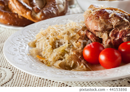 Pork knuckle with fried sauerkraut and tomatoes 44153898