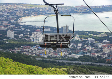 Seats of cable car to mountains against backdrop o 44155166