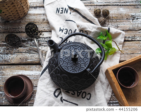 Black teapot, two bowls with green tea, mint  44155206