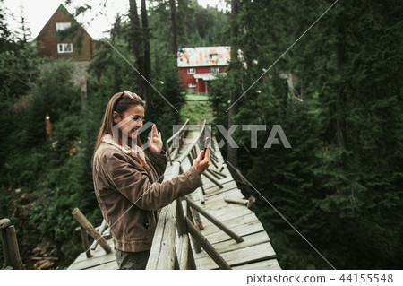Beautiful girl waving hello to friend during video chat on smartphone Beautiful girl waving hello to friend during video chat on smartphone 44155548