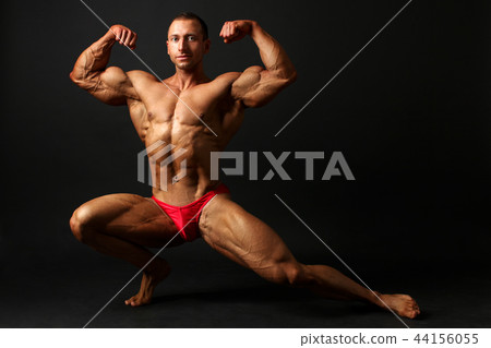 Young male bodybuilder standing knee bend, 44156055