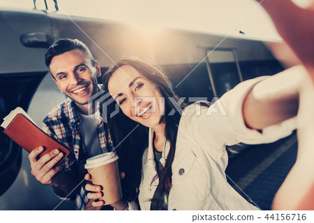 Optimistic girl and cheerful male taking selfie 44156716