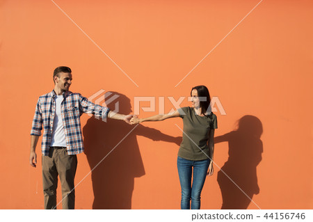 Cheerful girl holding arm of happy male 44156746