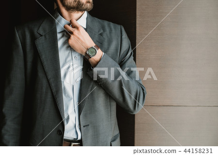 Stylish businessman is buttoning up his shirt Stylish businessman is buttoning up his shirt 44158231