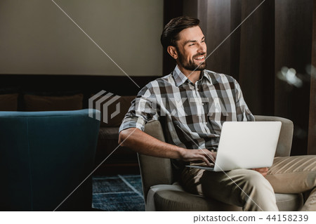 Delighted guy is having fun with laptop indoor 44158239