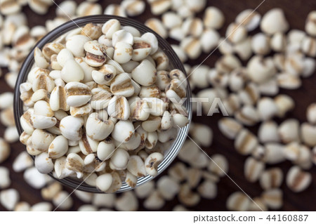 Millet grain in glass cups on wooden close up.. Millet grain in glass cups on wooden close up.. 44160887