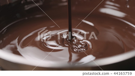 closeup pouring molten dark chocolate 44163759