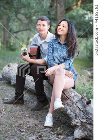 young couple walking in the forest, playing guitar 44165363