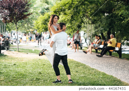 Handsome guy in his arms holding a beautiful girl Handsome guy in his arms holding a beautiful girl 44167431