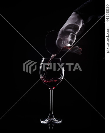 Hand pour red wine from decanter to glass 44168030