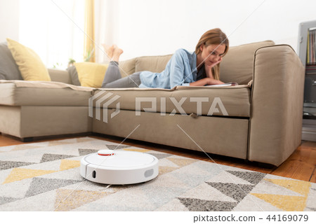Robotic vacuum cleaner cleaning the room 44169079