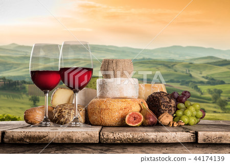 Delicious cheeses with wine on old wooden table. Delicious cheeses with wine on old wooden table. 44174139