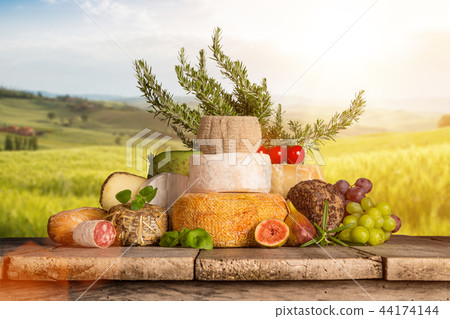Delicious cheeses with wine on old wooden table. Delicious cheeses with wine on old wooden table. 44174144