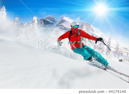 Skier skiing downhill in high mountains Skier skiing downhill in high mountains 44174148