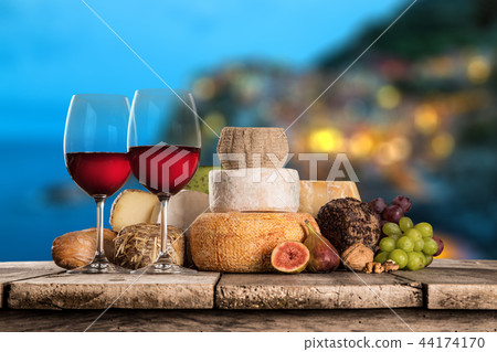 Delicious cheeses with wine on old wooden table. 44174170