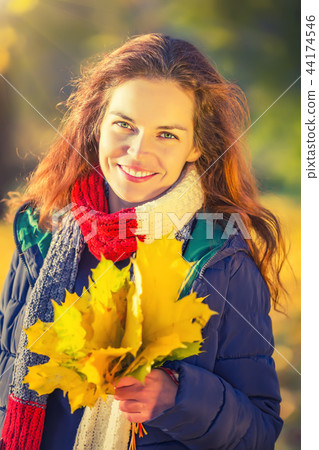 Portrait of young beautiful woman in autumn park 44174546