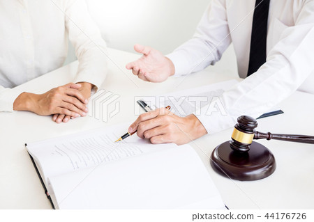 business people and lawyers discussing contract papers sitting a 44176726
