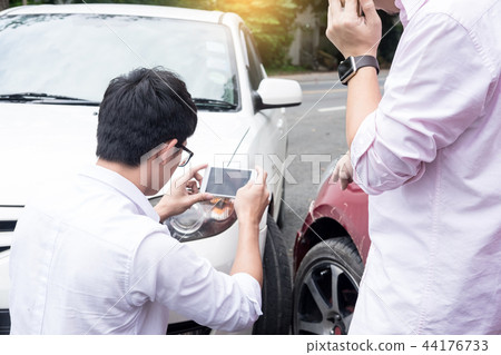 Male Driver take pictures of accident-damaged vehicle with a ho Male Driver take pictures of accident-damaged vehicle with a ho 44176733