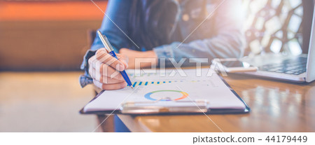 Woman hand writing on charts and graphs Woman hand writing on charts and graphs 44179449