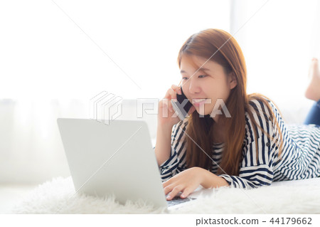 Beautiful woman lying on bed using laptop 44179662