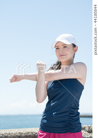 做舒展在海邊的年輕日本婦女 44180844
