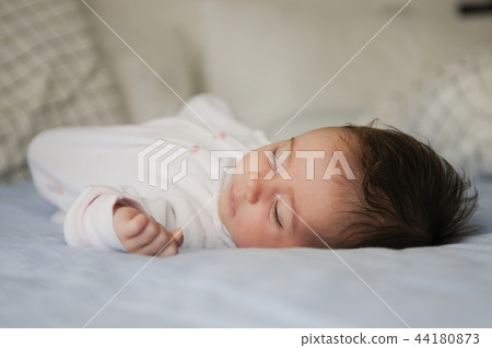 Newborn baby girl sleeping on blue sheets Newborn baby girl sleeping on blue sheets 44180873