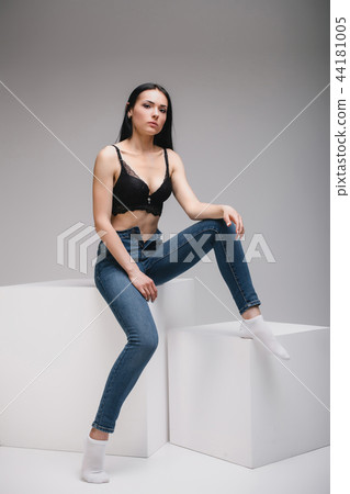 model sitting on cube in studio 44181005