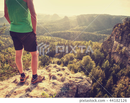Green singlet and black pants fearless boy on rock Green singlet and black pants fearless boy on rock 44182126