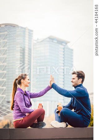 Woman and man giving hi-five after fitness sport in a city Woman and man giving hi-five after fitness sport in a city 44184168
