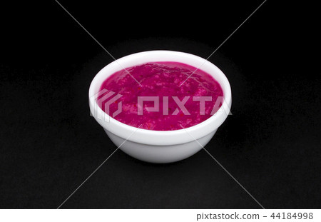 Red horseradish sauce in white bowl on black background 44184998