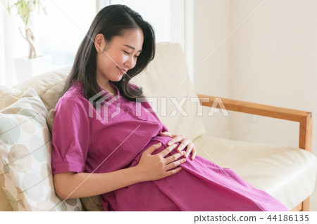 Young pregnant woman relaxing in the living room 44186135