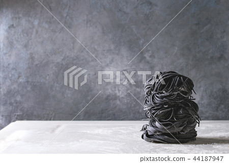 Fresh uncooked black pasta Fresh uncooked black pasta 44187947