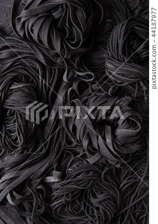 Fresh uncooked black pasta Fresh uncooked black pasta 44187977