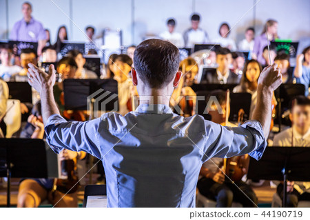Male school conductor conducting his student band Male school conductor conducting his student band 44190719