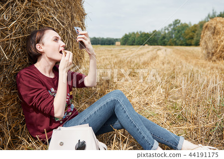 young girl having fun in the field with haystack 44191175