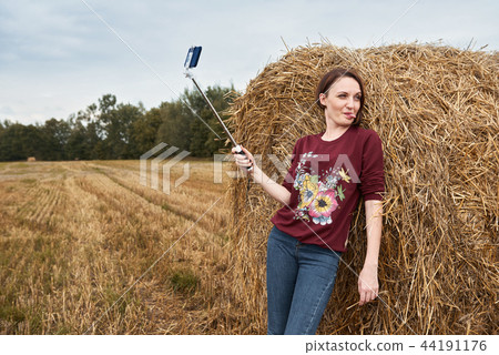 young girl having fun in the field with haystack 44191176