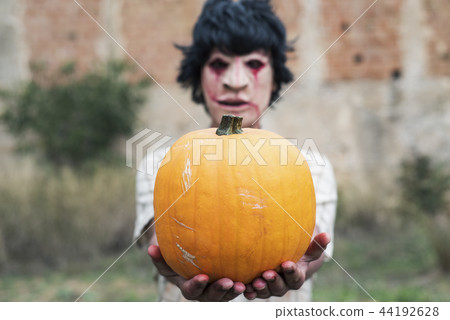 scary disfigured man with a pumpkin 44192628
