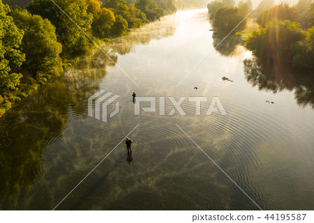 Aerial shot of a man fly fishing in a river during summer morning. Aerial shot of a man fly fishing in a river during summer morning. 44195587