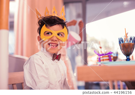 Happy boy wearing paper mask and looking ready for party Happy boy wearing paper mask and looking ready for party 44196156