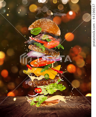 Big tasty burger with flying ingredients. Big tasty burger with flying ingredients. 44196637