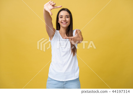 Young beautiful woman over isolated yellow background smiling making frame with hands and fingers 44197314
