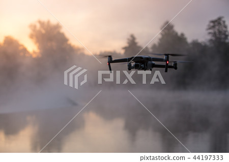 Drone copter with digital camera, river on background. Modern technology, UAV concept. Drone copter with digital camera, river on background. Modern technology, UAV concept. 44197333