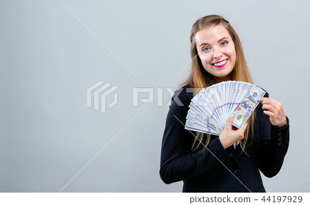 Young woman with a stack of cash USD 44197929