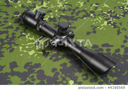 sniper scope on camouflage background sniper scope on camouflage background 44198569