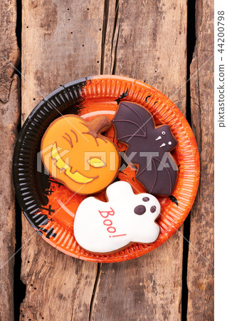 Plate with Halloween cookies on wooden background. 44200798